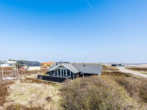 una casa en la cima de una colina con el océano detrás de ella en Holiday home Hvide Sande LXX, en Bjerregård