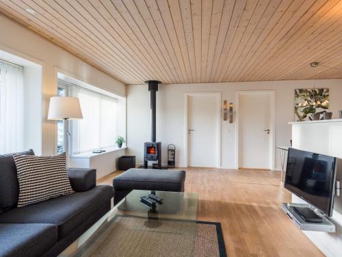 a living room with a couch and a tv at 4 person holiday home in Nørre Nebel in Nørre Nebel
