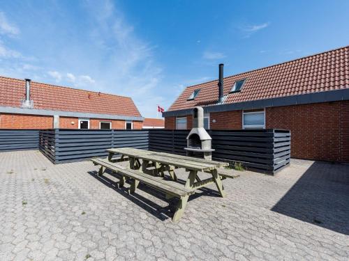 a wooden picnic table in front of a building at 6 person holiday home in Hvide Sande in Bjerregård