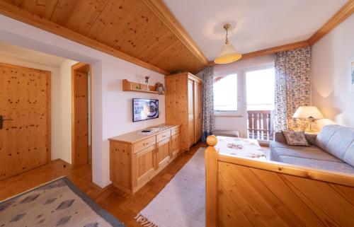 a living room with a blue couch and a window at Alpenhof in Ramsau am Dachstein