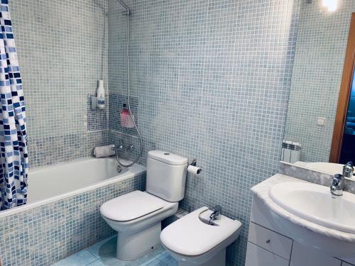 a bathroom with a white toilet and a sink at El Far de Palamós - Costa Brava in Palamós