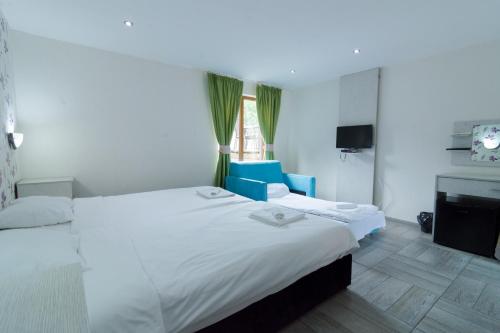 a hotel room with two beds and a window at Elinor Complex in Haskovo