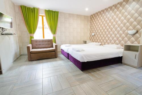 um quarto com 2 camas, uma cadeira e uma janela em Elinor Complex em Haskovo
