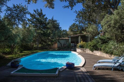 - une piscine dans une cour avec des chaises et des arbres dans l'établissement Suite Anduze, à Aramon