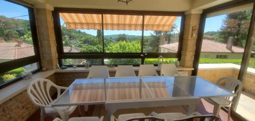 une salle à manger avec une table en verre et des chaises blanches dans l'établissement Villa Louise, à Sarlat-la-Canéda