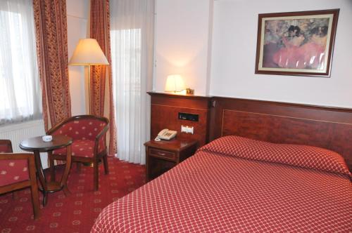 a hotel room with a bed and a chair and a table at Ozilhan Hotel in Ankara