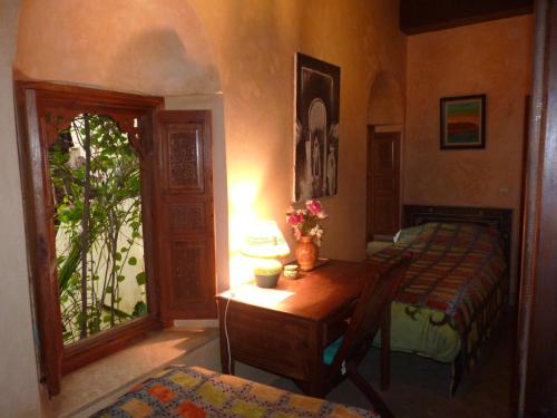 a bedroom with a table and a bed and a window at Riad Marlinea in Sale