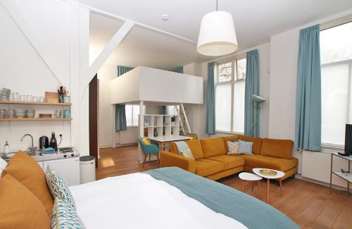 a bedroom with a bed and a living room at Citystays Deventer in Deventer