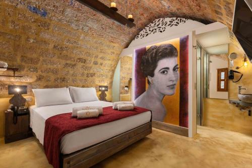 een slaapkamer met een bed met een schilderij van een vrouw bij 10GR Boutique Hotel & Wine Bar in Rhodos-stad