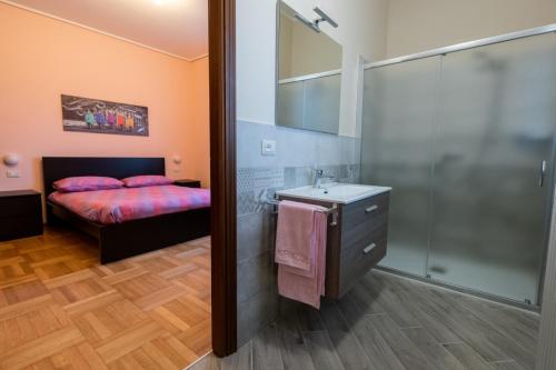 łazienka z łóżkiem, umywalką i prysznicem w obiekcie B&B Il castagno w mieście Roccavione