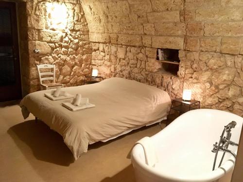 Schlafzimmer mit einem Bett mit einer Badewanne und einem Waschbecken in der Unterkunft Agriturismo Le Fornelle in Tricase