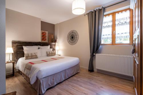 Un dormitorio con una cama grande y una ventana en La Cour St-Fulrad - Les Suites en Saint-Hippolyte