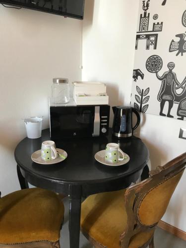a black table with two cups and a microwave at Palazzo Bolasco in Alghero