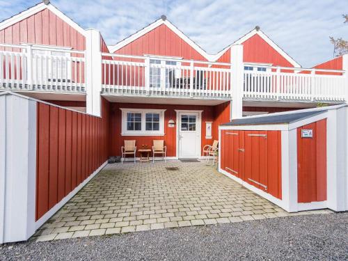 a red house with a balcony on top of it at 6 person holiday home in Blåvand in Blåvand
