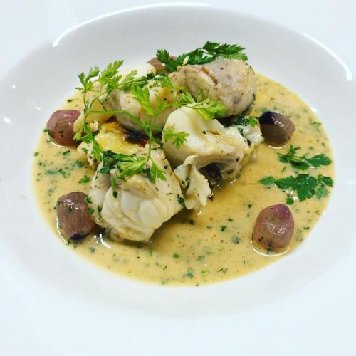a white plate with a dish of soup with meat and mushrooms at Ty Mawr Country Hotel & Restaurant in Carmarthen