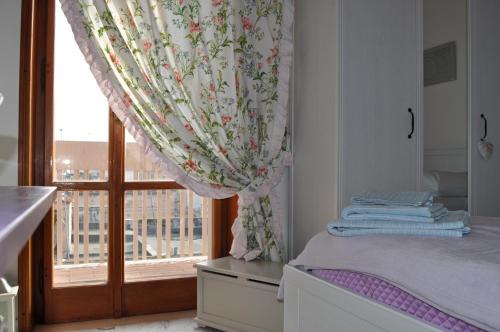 a bedroom with a window with a curtain and a bed at I Citri in Taranto