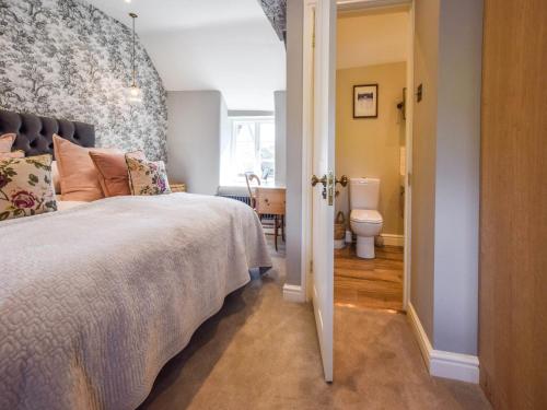 une chambre avec un lit et une salle de bain avec WC dans l'établissement Lovell Cottage, à Witney