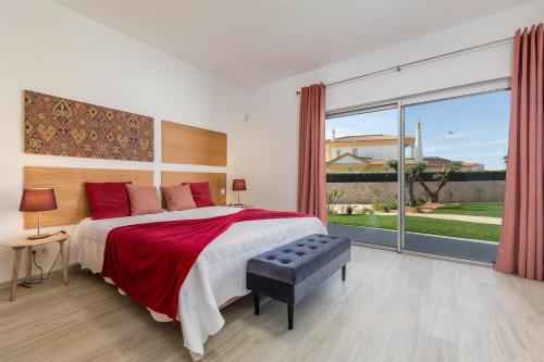 a bedroom with a large bed and a large window at Villa Alfazema - heatable pool in Albufeira