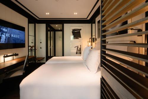 a hotel room with two beds and a tv at Seventy Barcelona in Barcelona