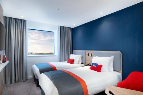 two beds in a hotel room with blue walls at Holiday Inn Express - London Heathrow T4 by IHG in Hillingdon