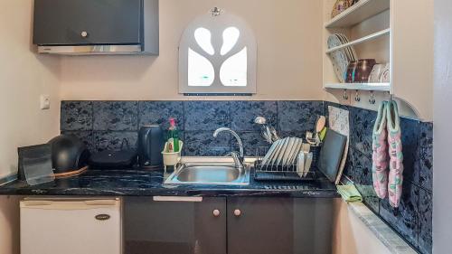 a kitchen counter with a sink and a window at Studio with city view in Tírnavos