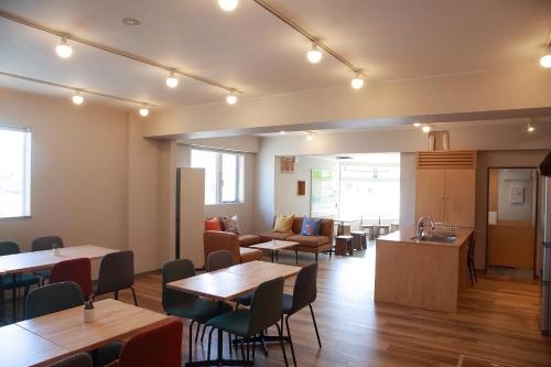 a dining room with tables and chairs and a kitchen at THE STAY WAKKANAI in Wakkanai