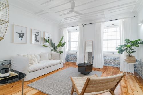 a white living room with a couch and a table at Casa Boma Lisboa - Typical and Spacious Apartment - Lapa II in Lisbon