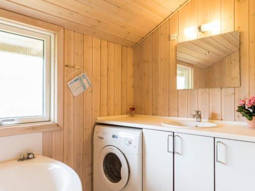 a bathroom with a washing machine and a sink at 6 person holiday home in Tarm in Tarm