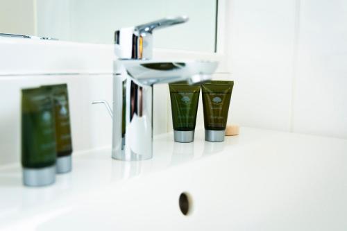 a bathroom counter with a sink and two cups at Mitchell Hall in Cranfield