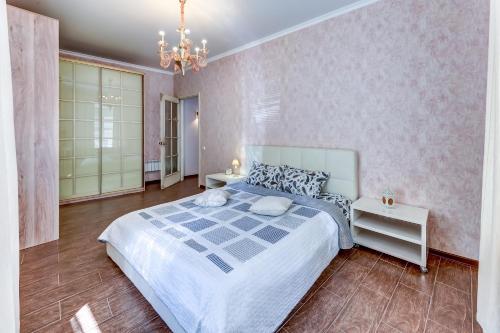 a bedroom with a large bed and a chandelier at Апартаменты Веста на Казанской in Saint Petersburg