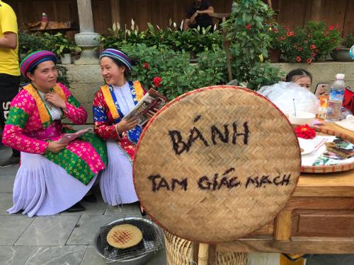 two women are standing next to a large drum at Meo Vac Cosy Hostel in Mèo Vạc