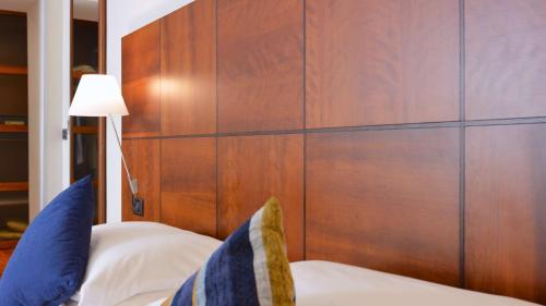 a bedroom with a large wood paneled wall at Best Western Hotel Crimea in Turin