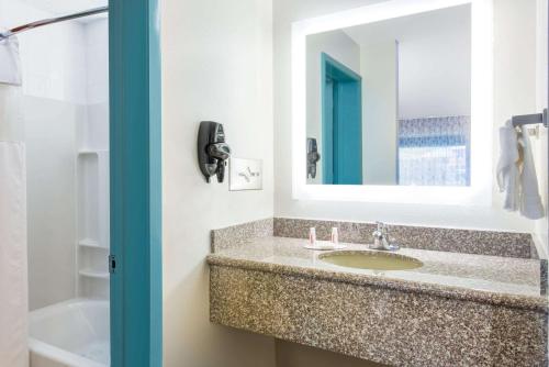 a bathroom with a sink and a mirror at Howard Johnson by Wyndham Ocala FL I-75 in Ocala