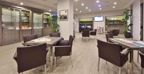 a restaurant with tables and chairs in a room at Best Western Plus Borgolecco Hotel in Arcore