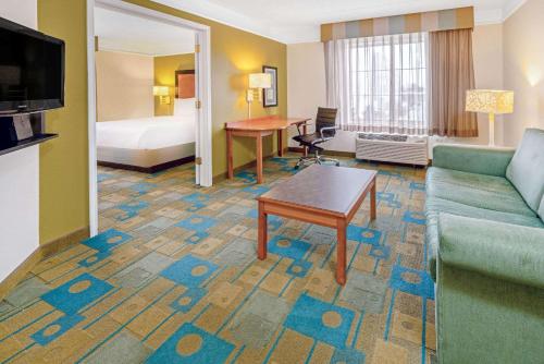 a hotel room with a couch and a bed at La Quinta by Wyndham Salt Lake City Airport in Salt Lake City