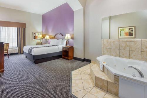 a hotel room with a bed and a bath tub at La Quinta by Wyndham Gainesville in Gainesville