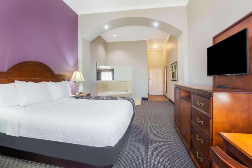 a hotel room with a bed and a flat screen tv at La Quinta by Wyndham Gainesville in Gainesville