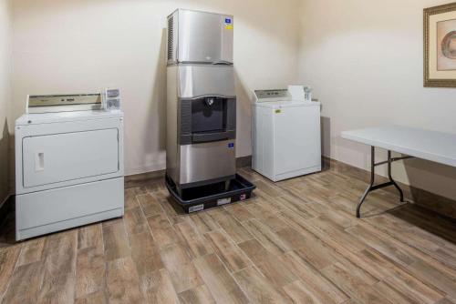 a room with a refrigerator and two washers and a table at La Quinta by Wyndham Gainesville in Gainesville