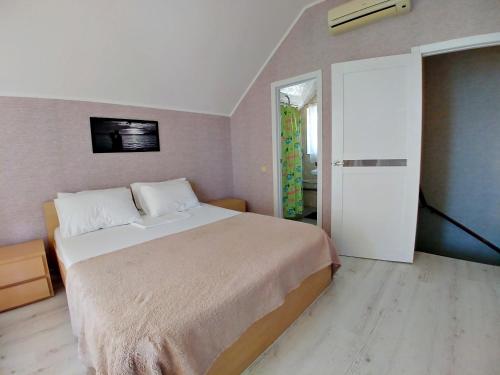 a bedroom with a large bed and a sliding door at Котеджі на приватному пляжу - Совіньйон 2025 in Odesa