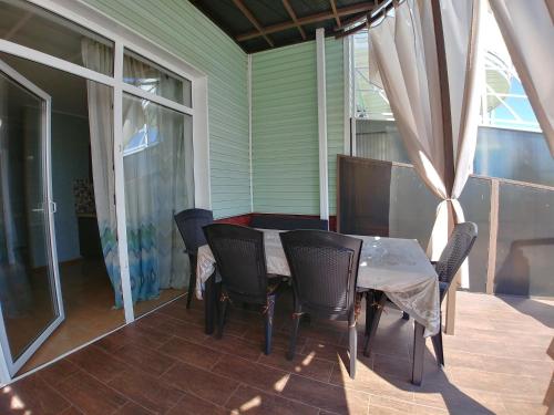 un patio con mesa y sillas en un porche en Котеджі на приватному пляжу - Совіньон 2024, en Odessa