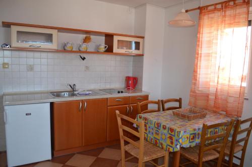 a kitchen with a table and a table and chairs at Apartments Leticia in Baška