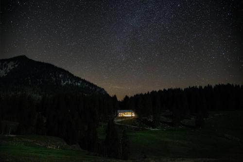 une maison sous un ciel étoilé la nuit dans l'établissement Spitzing Lodge Ferienwohnungen - Wanderparadies in den Bergen, à Spitzingsee