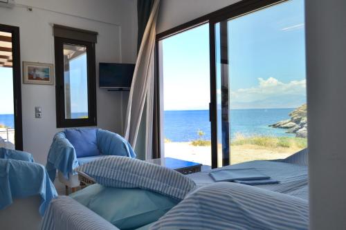 a room with a view of the ocean from a bedroom at Hersonissos Andros in Gavrion