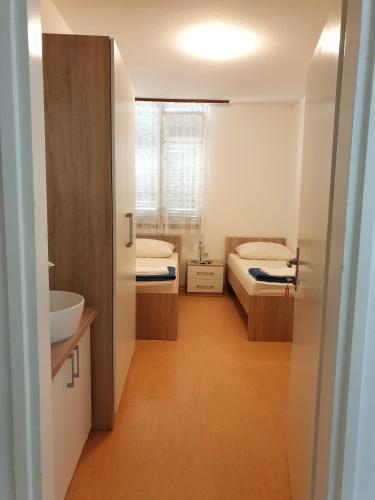 a small bathroom with two beds and a sink at Youth Hostel Pinesta in Novigrad Istria
