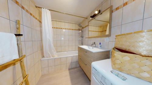 ein Badezimmer mit einer Badewanne, einem Waschbecken und einem Spiegel in der Unterkunft Duplex des Dominicains - 1 Parking GRATUIT - Hypercentre 6 personnes in Colmar