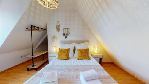 ein Schlafzimmer mit einem Bett mit gelben Kissen in der Unterkunft Duplex des Dominicains - 1 Parking GRATUIT - Hypercentre 6 personnes in Colmar