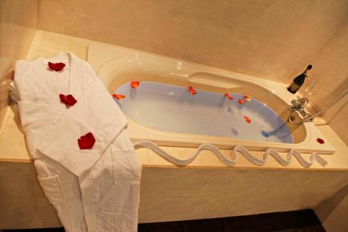 a room with a bath tub and a robe at Plaza Hotel in Kokshetau