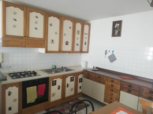 een keuken met houten kasten en een fornuis met oven bij Cif apartment 3 in Pastena