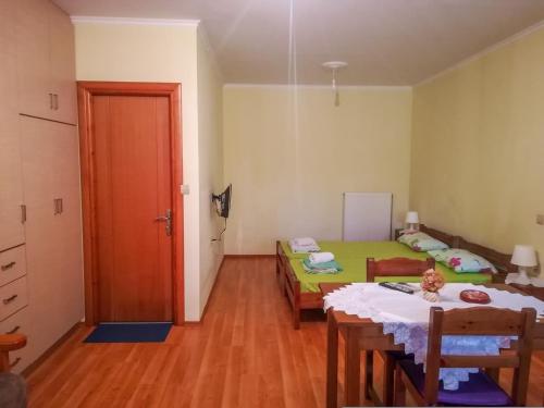 a room with a table and a bed and a door at Mιχαλης Apartments in Paramythia