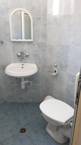 a bathroom with a white toilet and a sink at Майстор Костадин - 1878 in Obzor